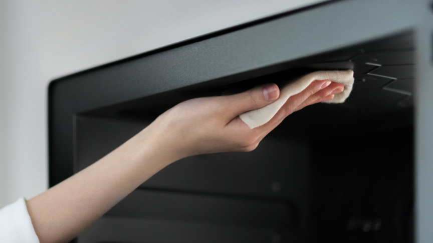 電子レンジ内を掃除しているイメージの写真