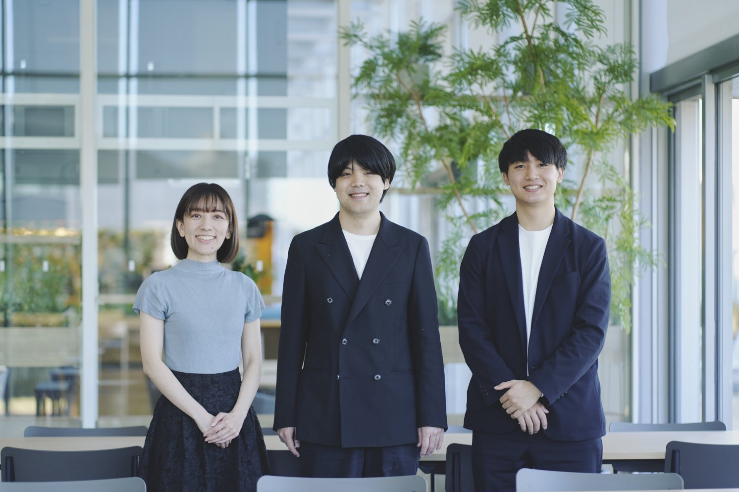 こちら側を見て立つ笑顔の3人の写真