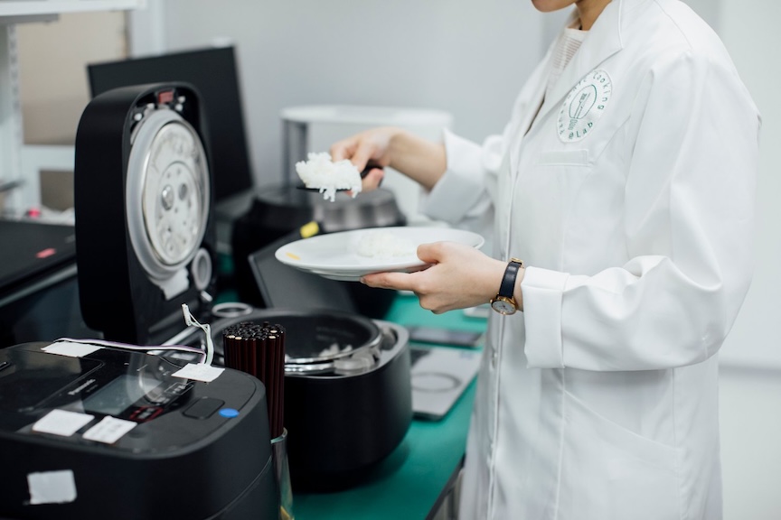 炊飯器から白米をよそっている写真