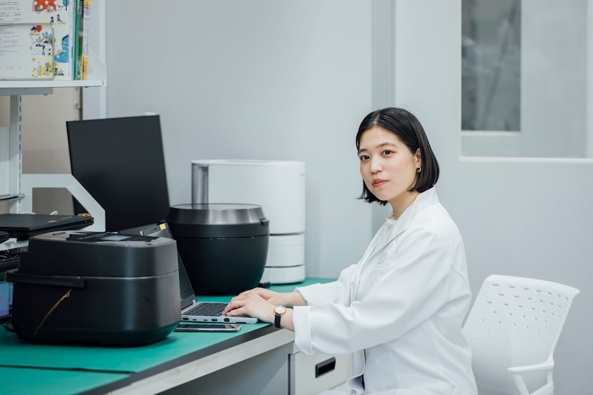 ノートパソコンに手を置いている萩成美の写真