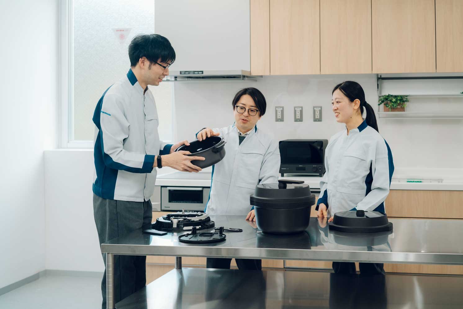 「オートクッカー」を囲んで会話する中須慧さんと西平康隆さんと庄内星加さん