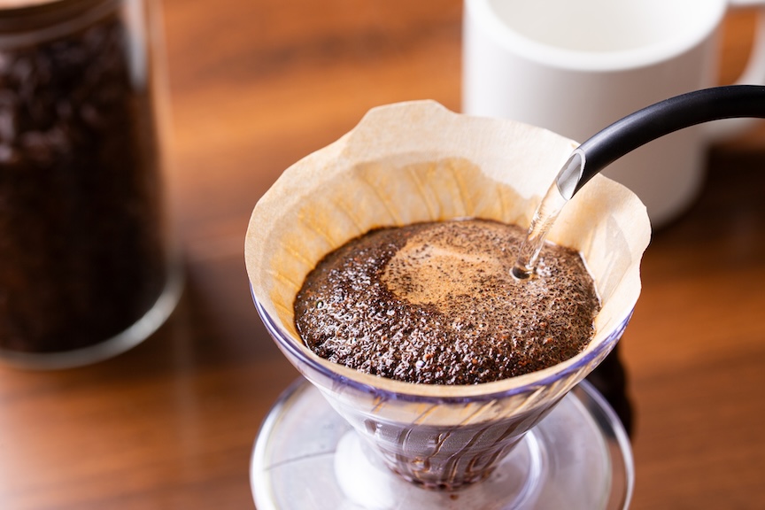 ペーパードリッパーにセットしたコーヒー粉にお湯を注ぐ写真