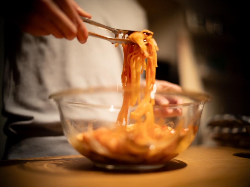 耐熱ボウルで調理したパスタをすくっている様子の写真