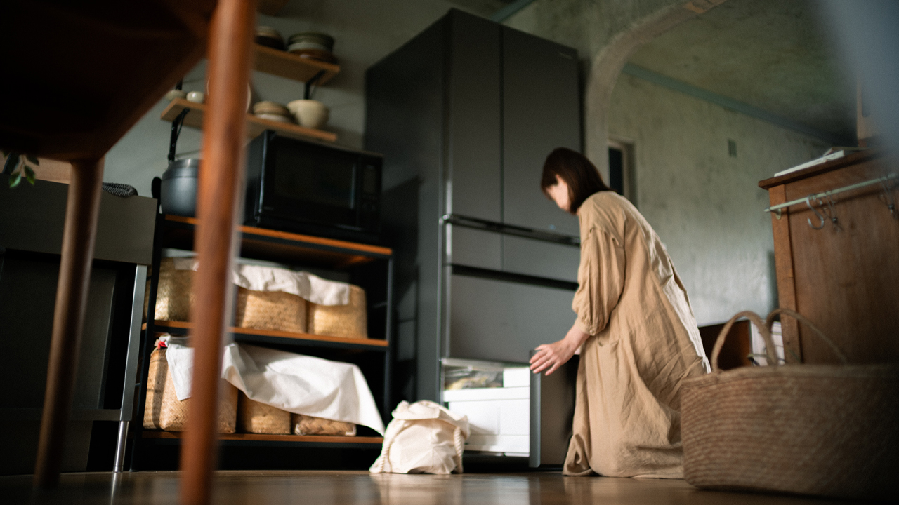 冷蔵庫から食材を取り出す女性の写真