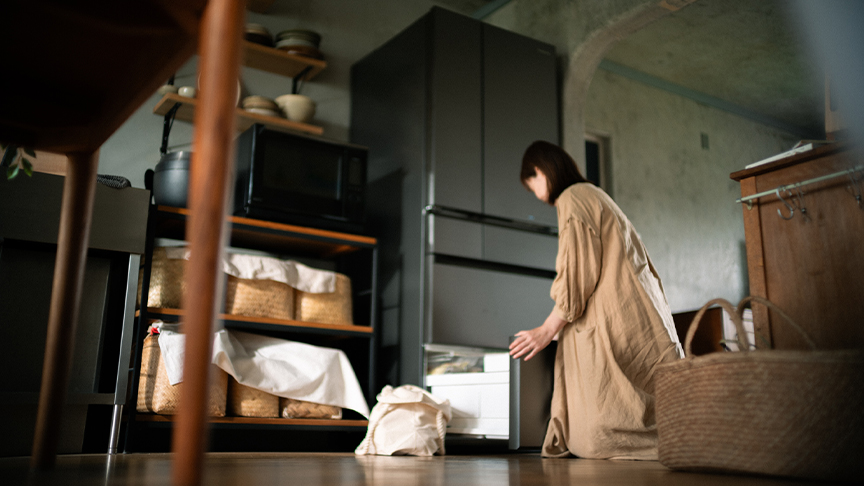 冷蔵庫から食材を取り出す女性の写真