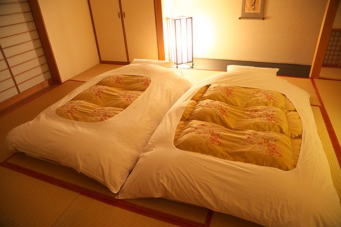 写真：ホテルの部屋に布団が敷かれているイメージ