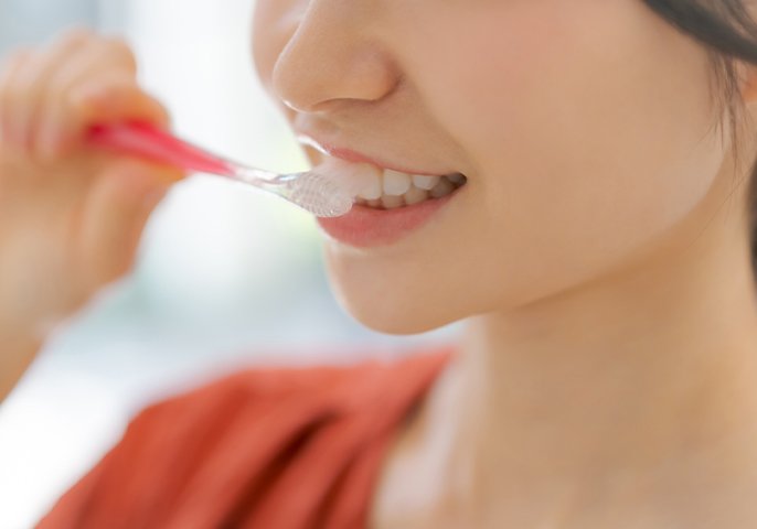 写真：歯磨きをしている女性の口元のイメージ