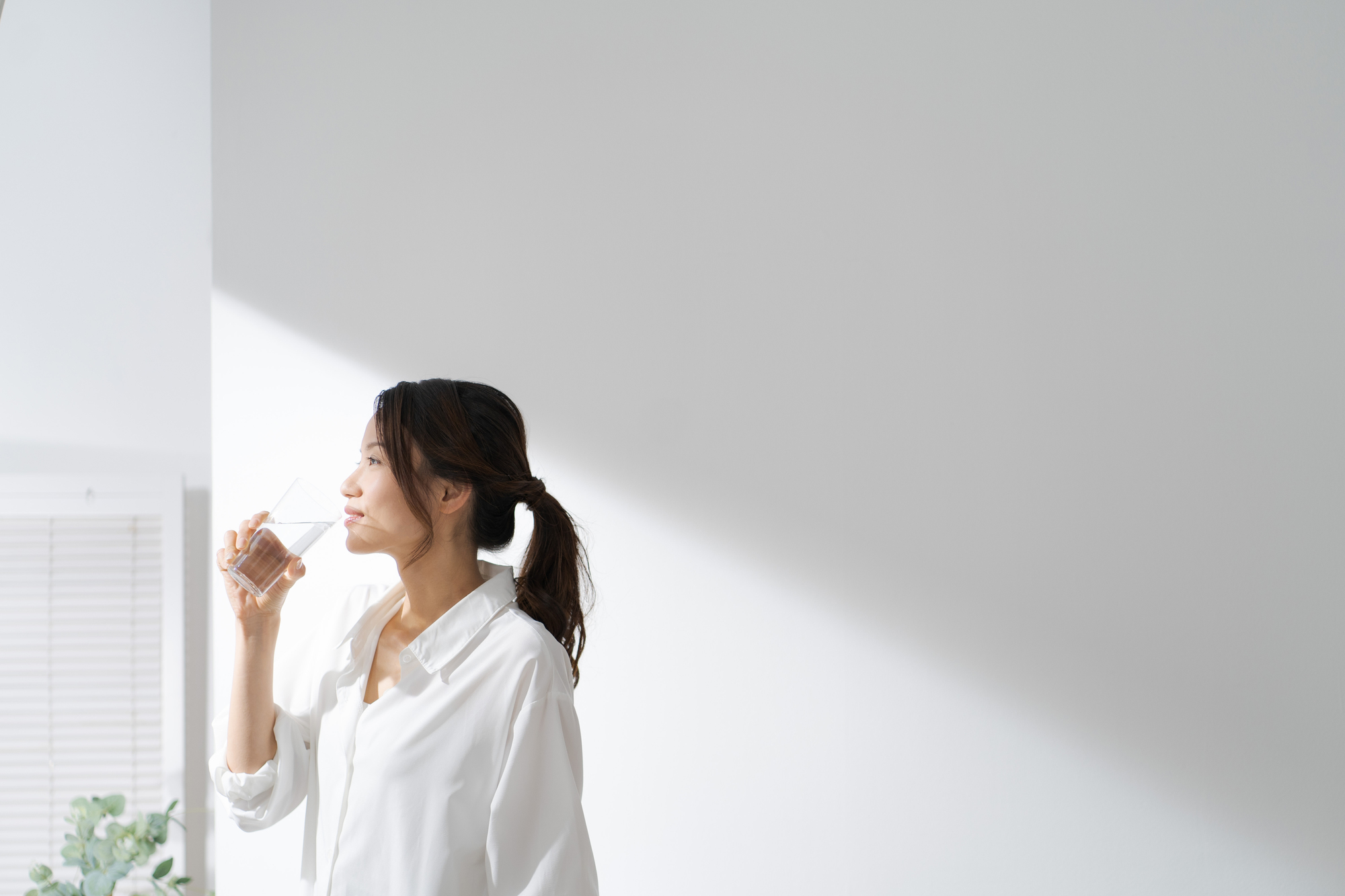 グラスに入った水を飲む女性