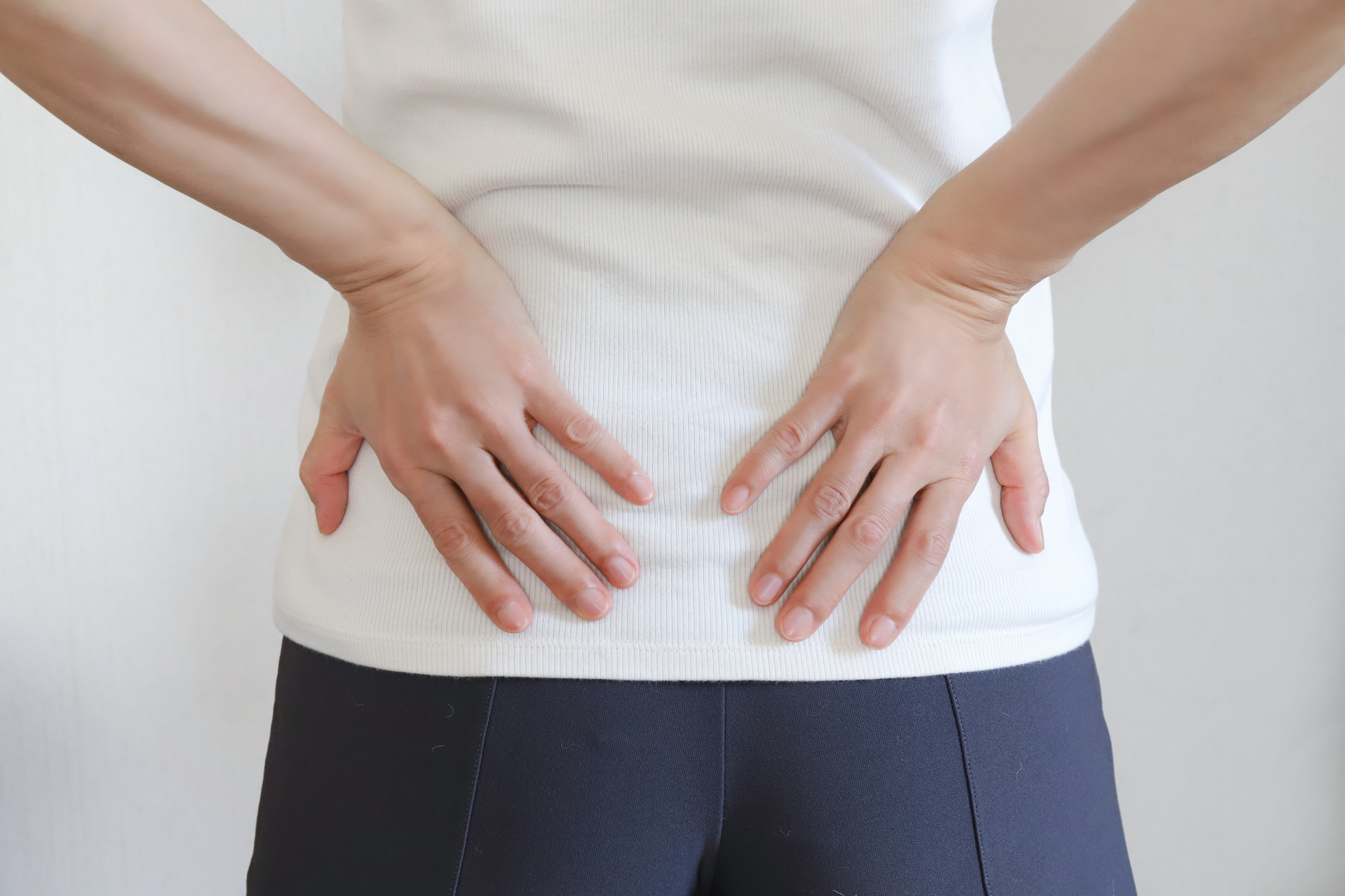 腰に手を当てる女性の後ろ姿