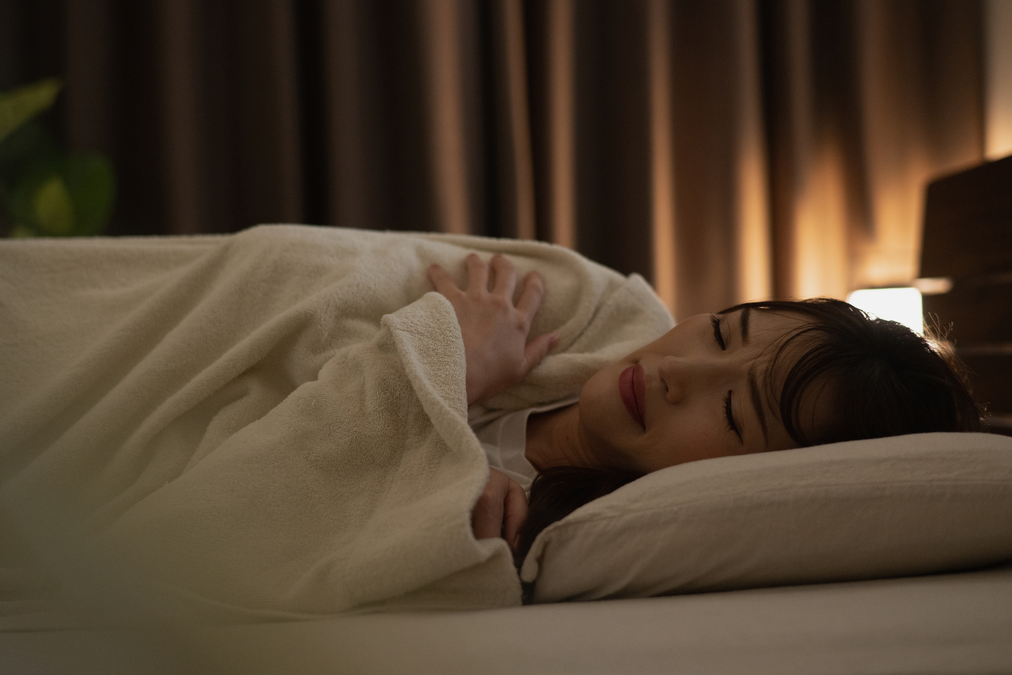 寝室でベッドに入る女性