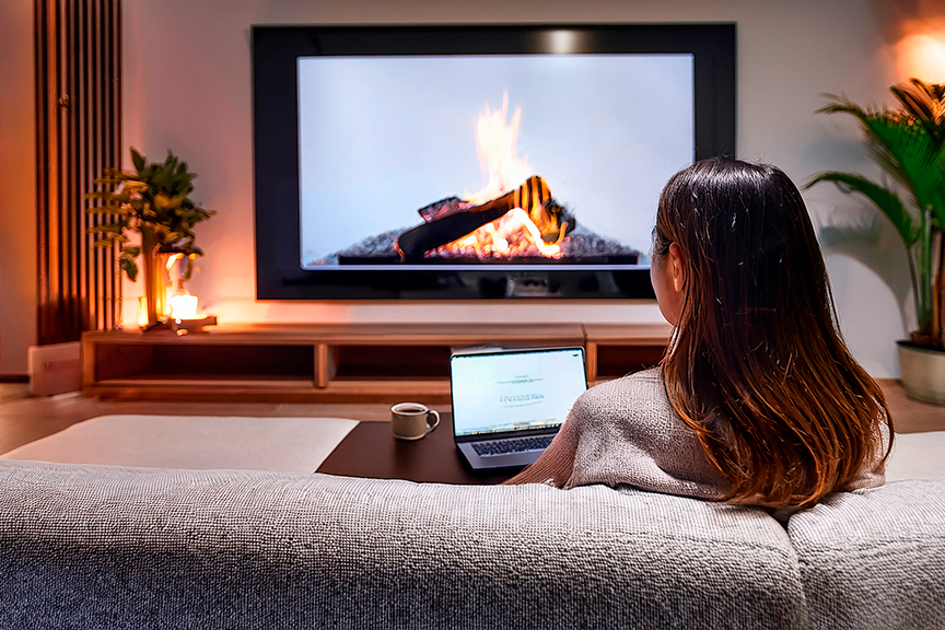 女性が家でテレビを見ている様子