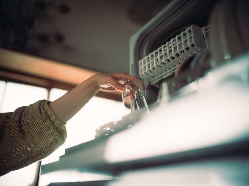 食洗機にグラスを入れている手元の様子。