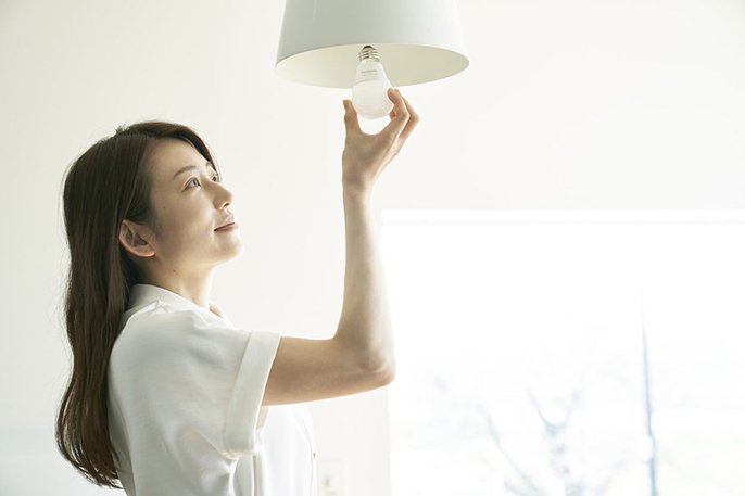 写真：LED電球を交換する女性