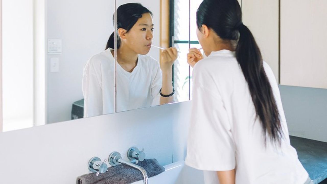 洗面台で歯を磨いている女性の写真