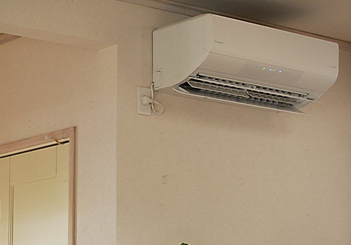 写真：部屋に設置されたエアコンが起動しているイメージ