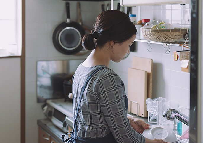 写真：女性がキッチンで洗い物をしているイメージ