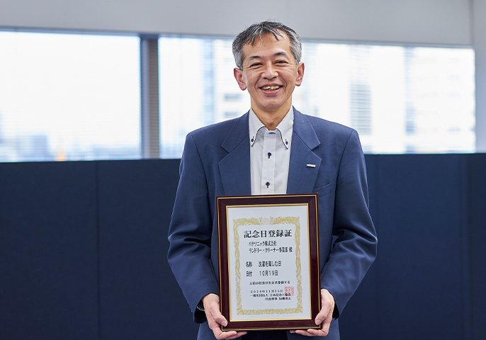 國司 有香さんが「洗濯を楽しむ日」の記念日認定された額縁を持っているイメージの写真