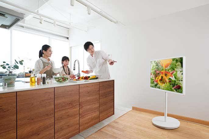 写真：キッチンでテレビを見ながら料理している家族のイメージ