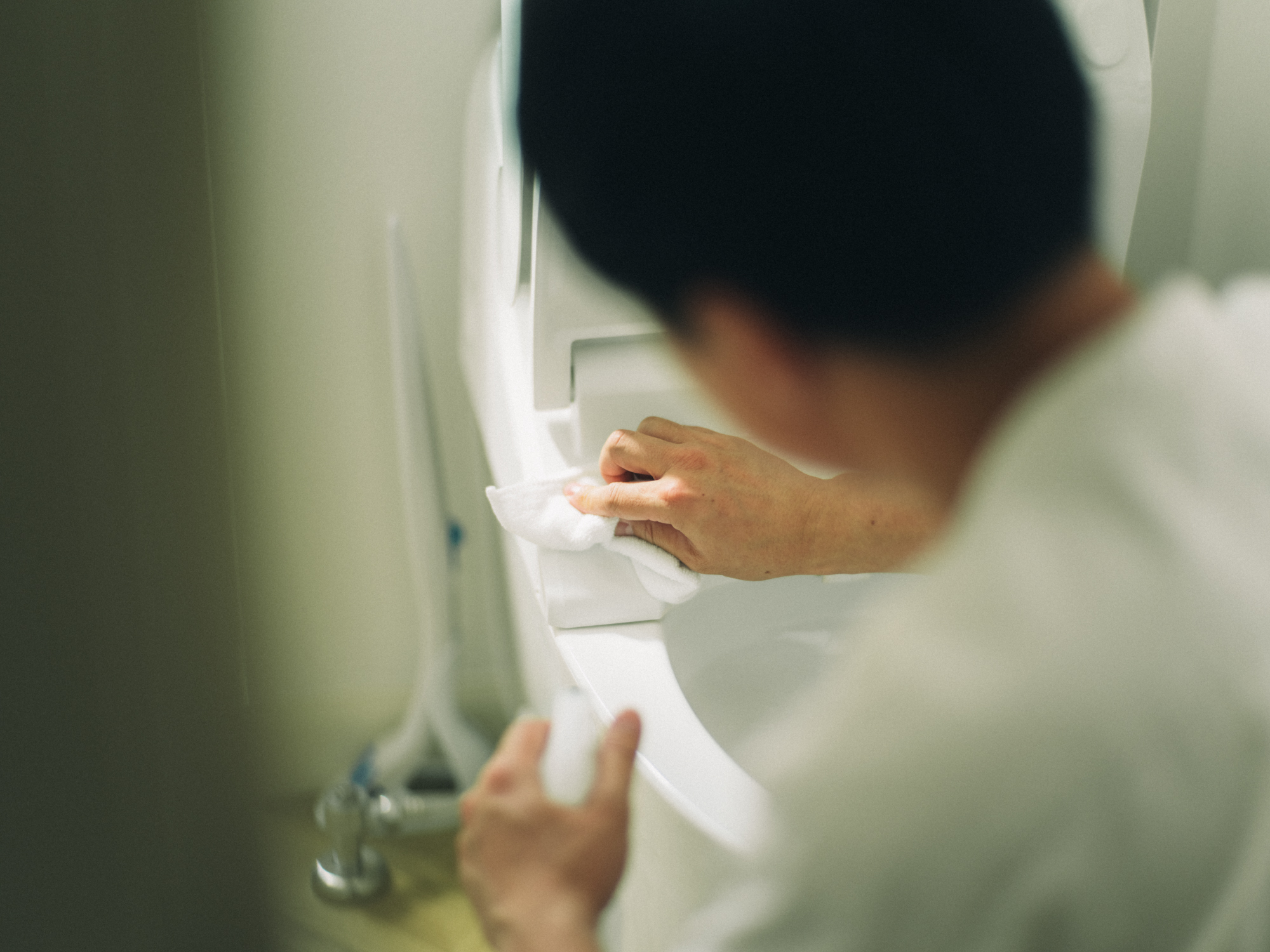 トイレの汚れを拭き取る人の写真