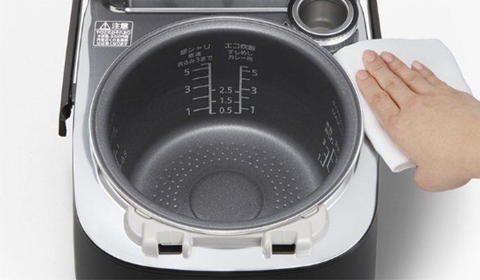 写真：炊飯器本体をふきんで拭き上げてるイメージ