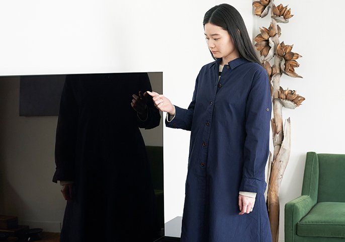写真：女性がテレビの前に立っているイメージ