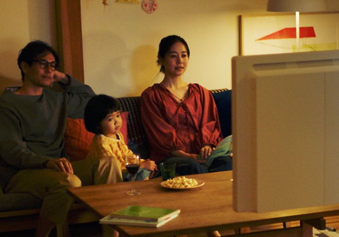 写真：家族3人でテレビを見ているイメージ