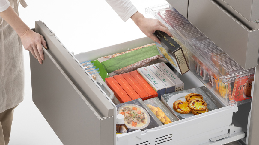 写真：冷蔵庫の真ん中にある冷凍庫からものを取り出す人