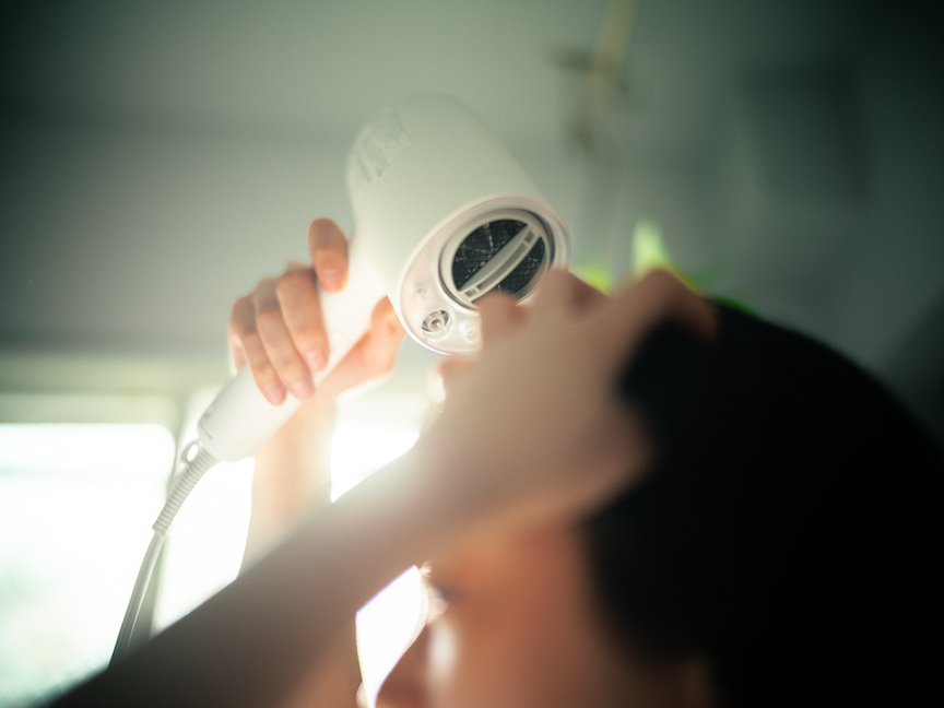 写真：ドライヤーで髪を乾かす様子