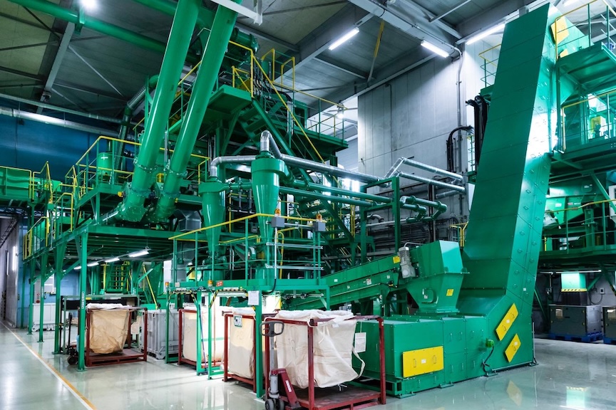 プラスチックを種類に選別し、各袋に流し込む機械の写真