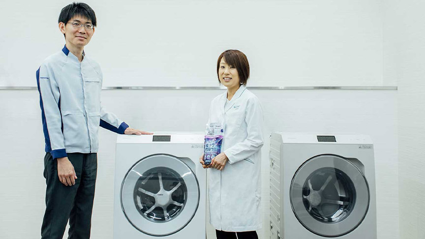 ドラム式洗濯乾燥機の前に立つ喜多亜矢子さんと工藤慶之の写真