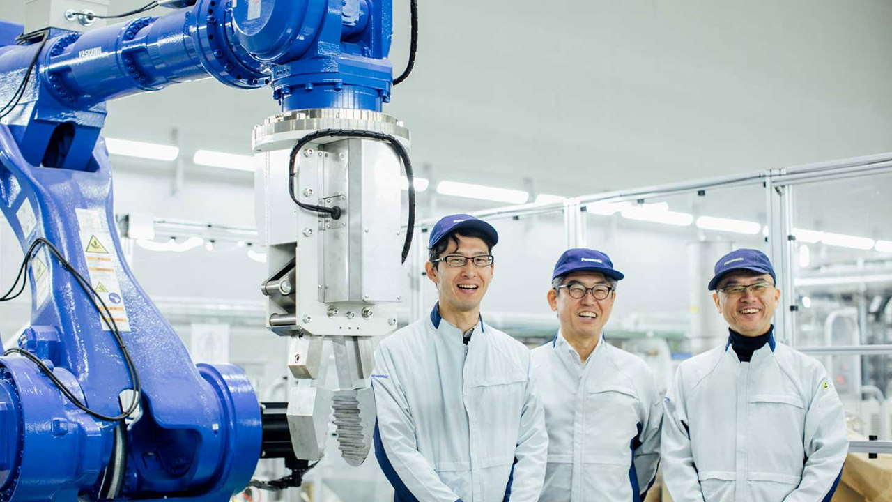 ロボットの前に笑顔で立つ古川卓さんと山内大さんと楠元寛史さんの写真