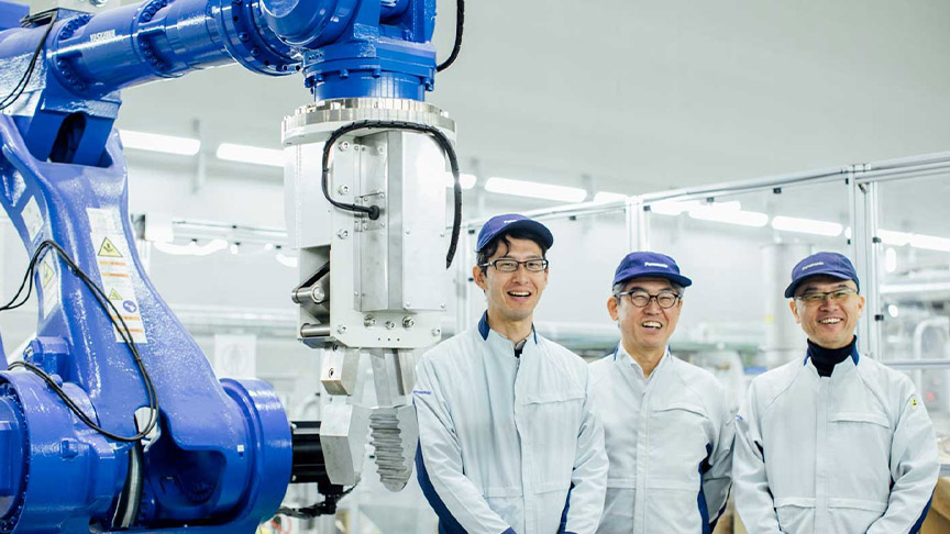 ロボットの前に笑顔で立つ古川卓さんと山内大さんと楠元寛史さんの写真