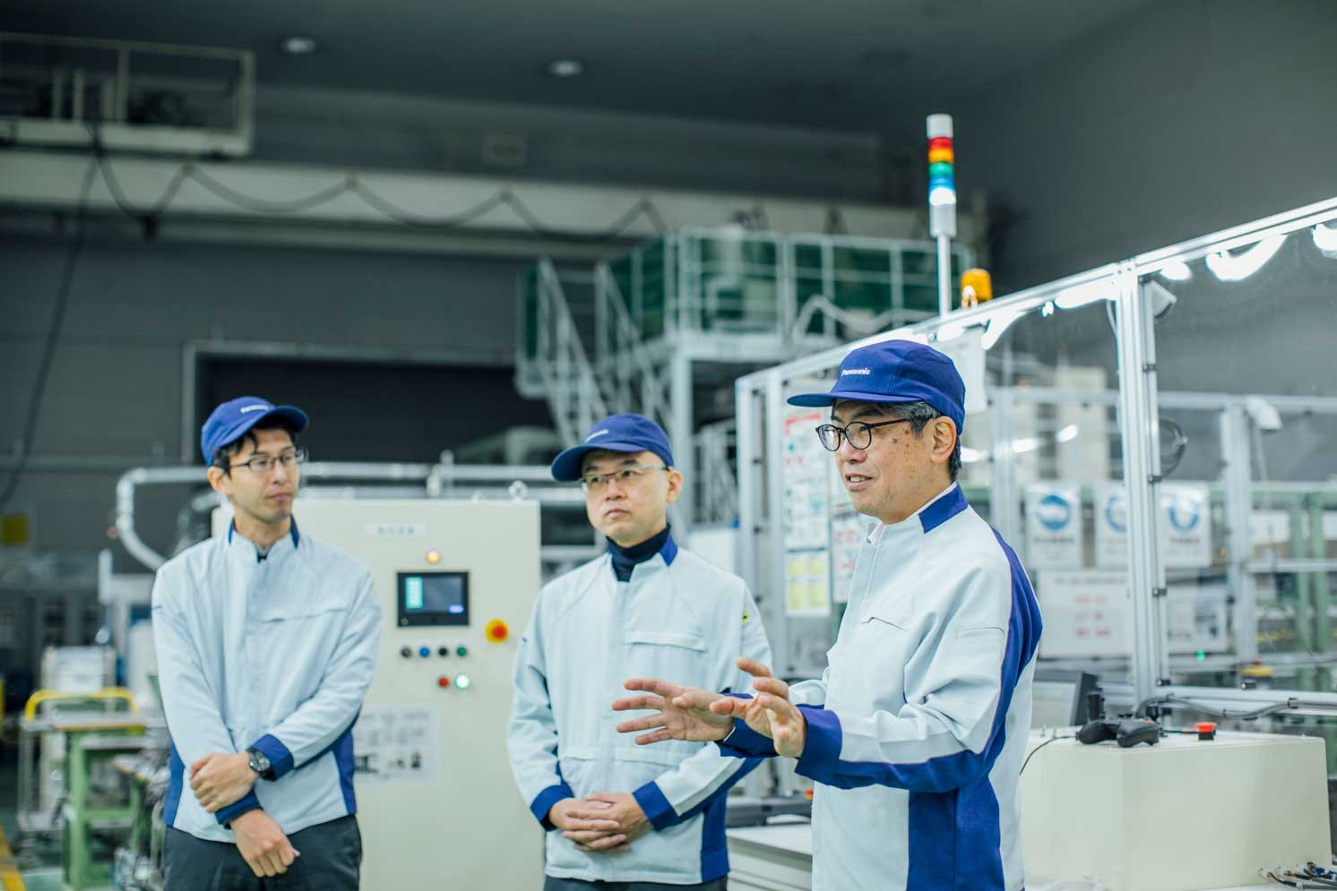 工場で話している山内大さんと話を聞いている古川卓さんと楠元寛史さんの様子の写真