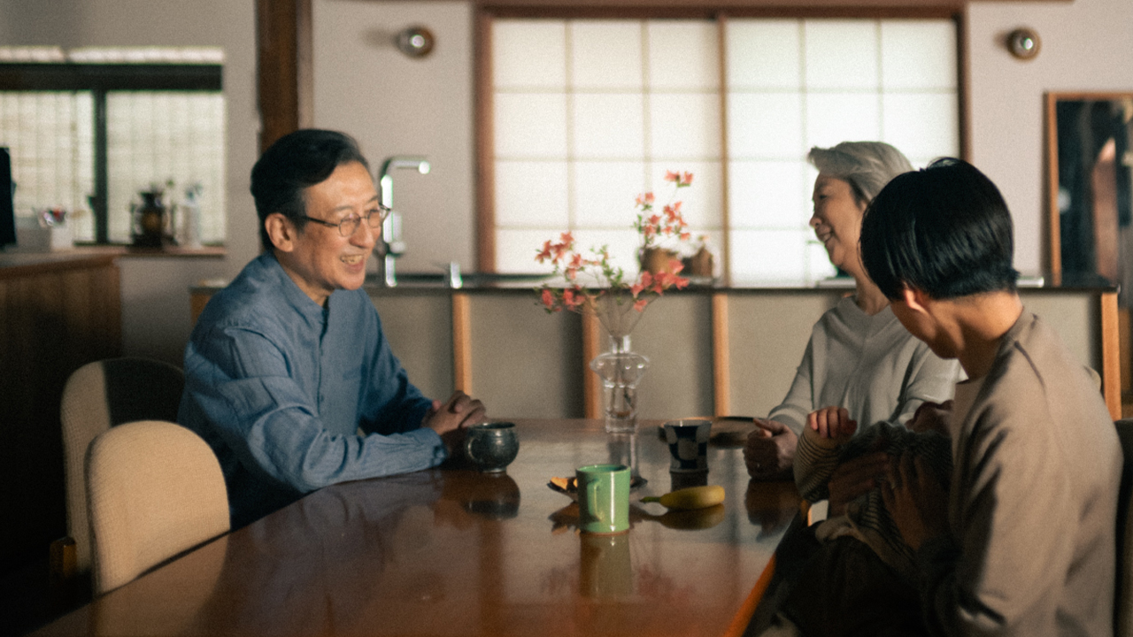 食卓を囲んで話している家族の様子の写真