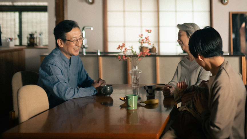 食卓を囲んで話している家族の様子の写真