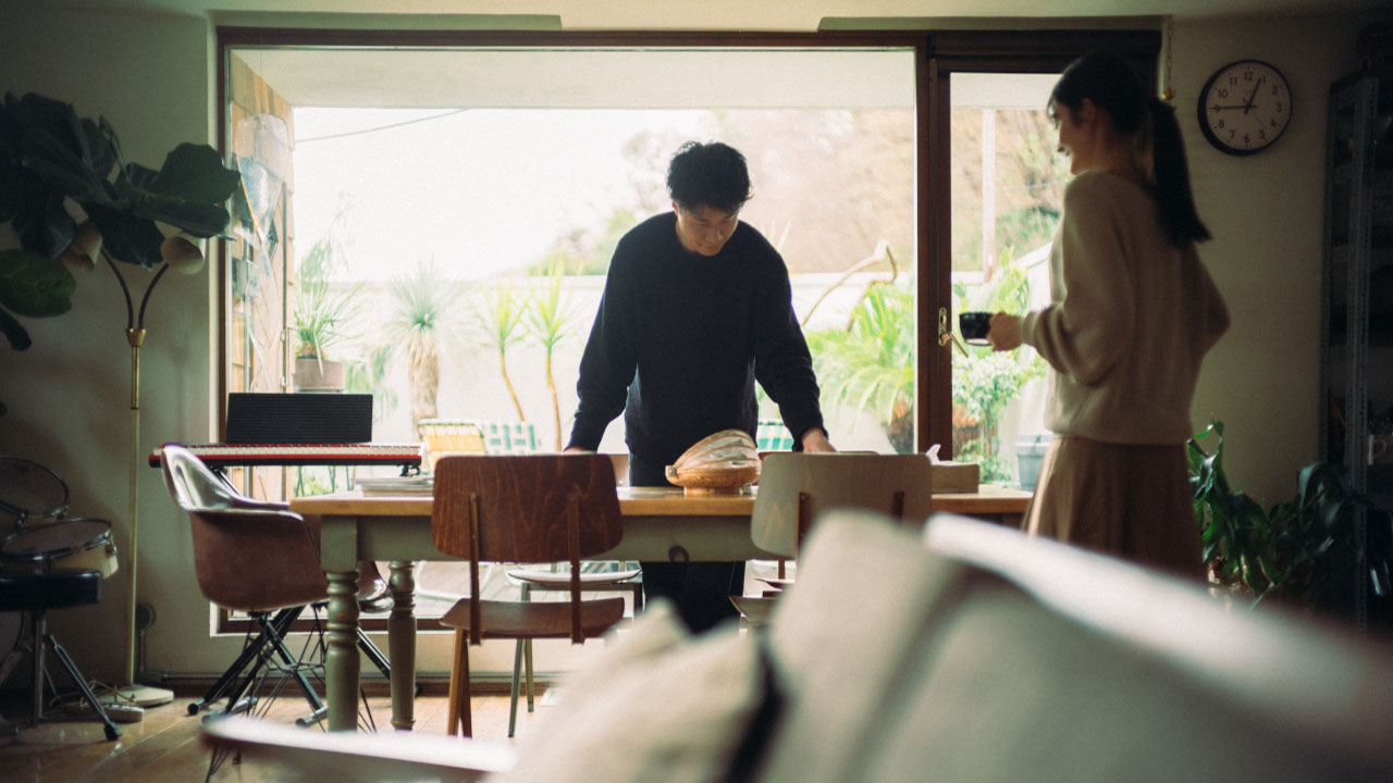 室内のダイニングで2人がテーブルを囲んで過ごしている様子。