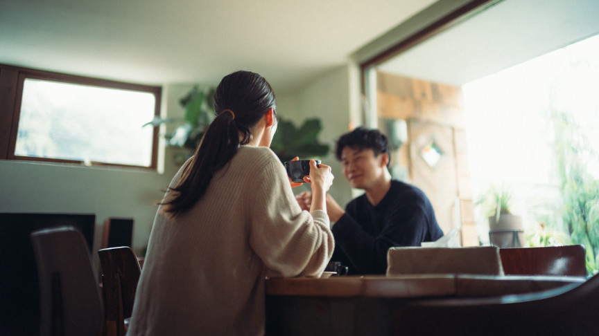 テーブルを挟んで向かい合う2人が会話している室内の様子。