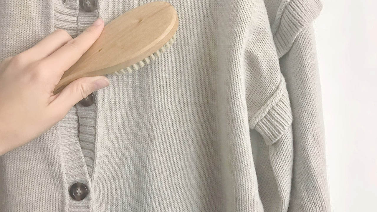 ニットカーディガンをブラシでお手入れしている様子。