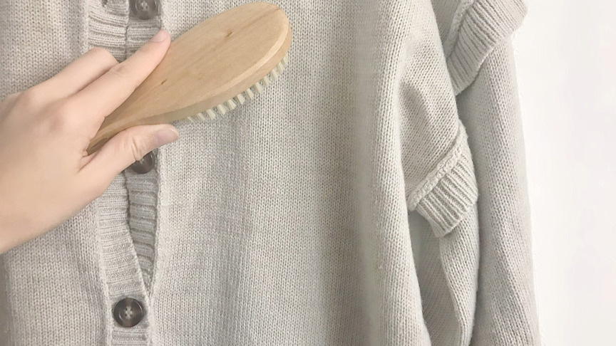 ニットカーディガンをブラシでお手入れしている様子。