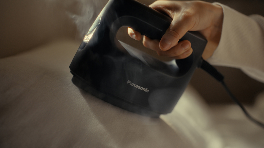 衣類にスチームアイロンをかけている様子。