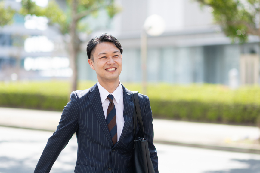 写真：スーツを着た笑顔の男性のイメージ