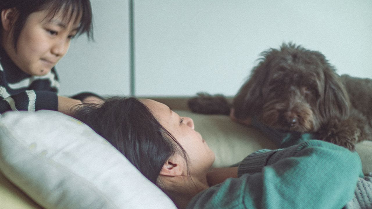 横になっている女性と子どもと犬の写真
