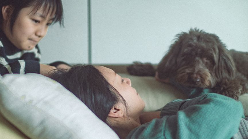 横になっている女性と子どもと犬の写真