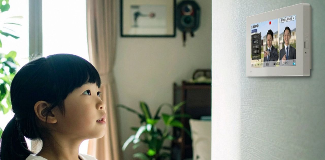 子供がインターホンを見ている様子の写真