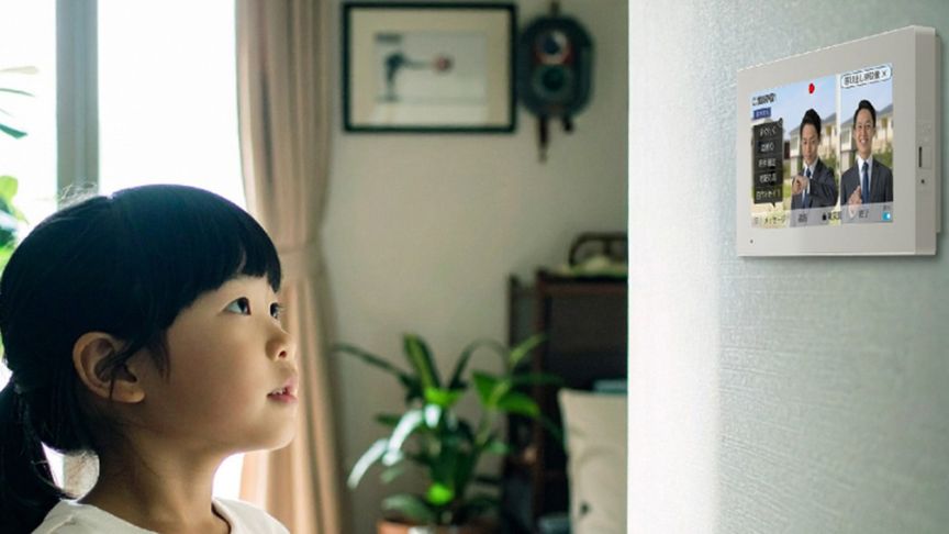 子供がインターホンを見ている様子の写真