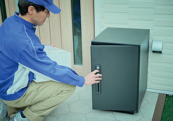 配達員が宅配BOXに荷物を入れているイメージの写真