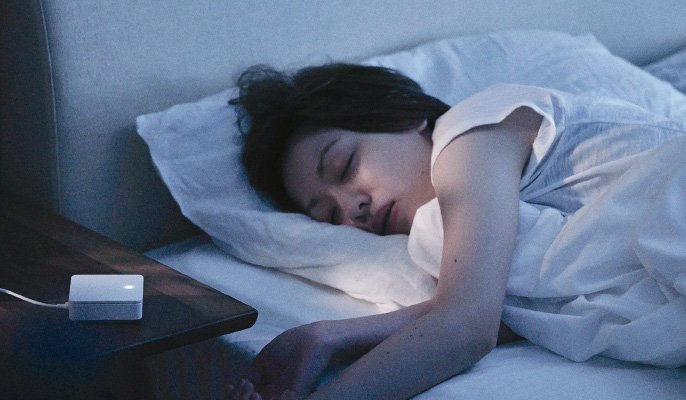 写真：女性がベッドで横向きに寝ているイメージ