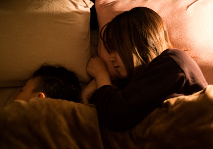 女性と子供が寝ている様子の写真