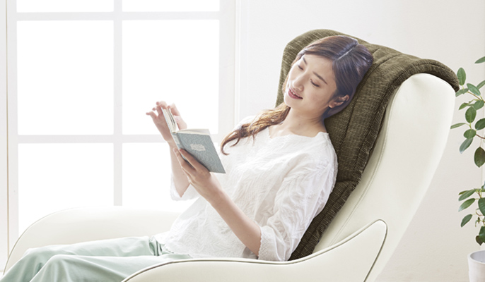 マッサージソファで本を読む女性のイメージ