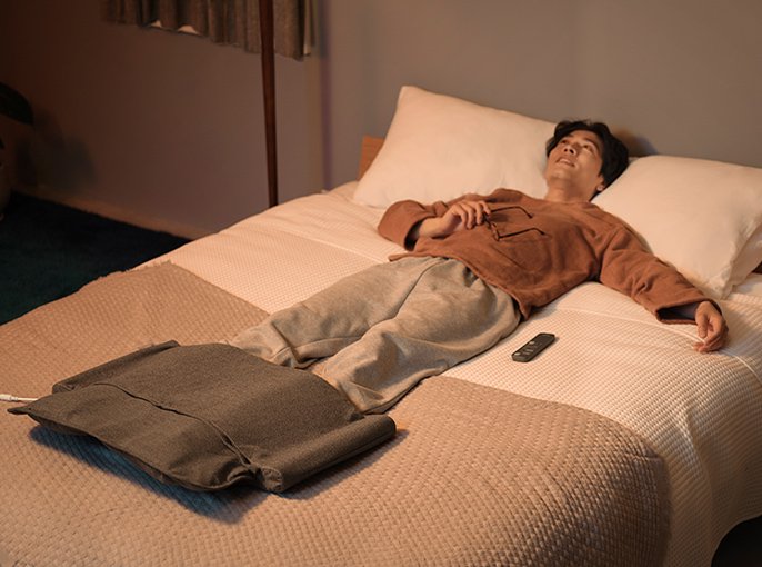 写真：ベッドに横たわる男性